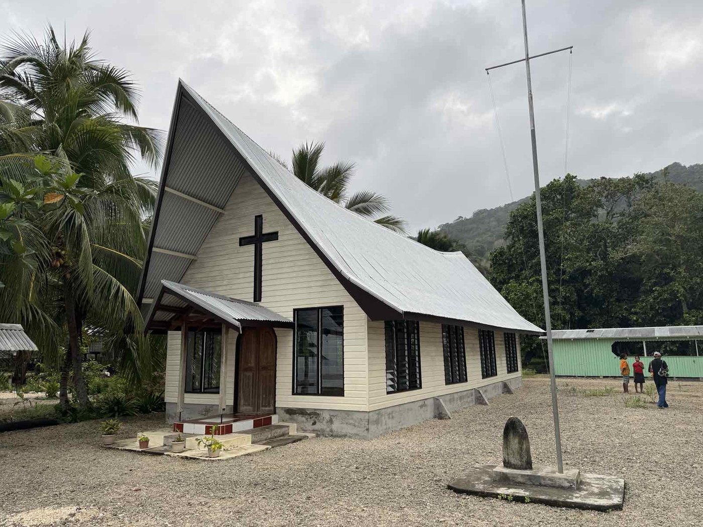 A white church building with a steep roof in Milne Bay Province